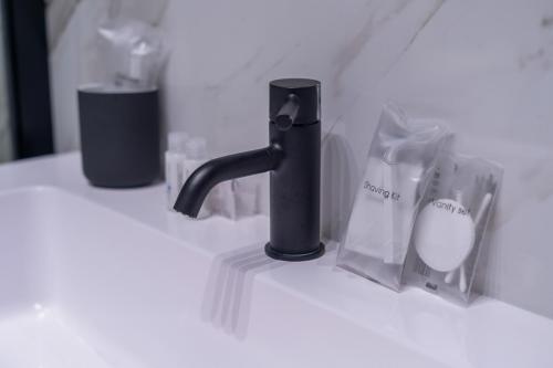 a bathroom counter with a black faucet and some bags at Tree Luxury in Baronissi