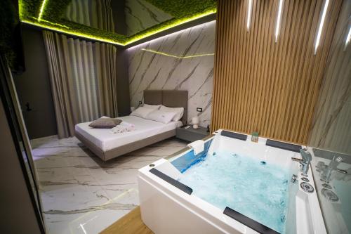 a hotel room with a tub and a bed at Tree Luxury in Baronissi
