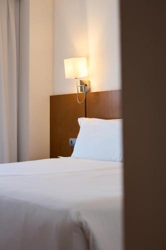 a hotel room with a bed and a lamp at Senator Granada in Granada