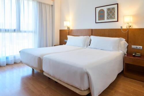 a large white bed in a hotel room at Senator Granada in Granada