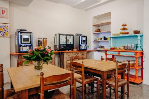 a dining room with a table and chairs and a kitchen at Hostel Demain c'est loin in Hendaye