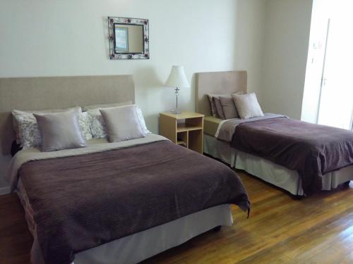 a hotel room with two beds and a mirror at Uitenhage Apartments in Uitenhage