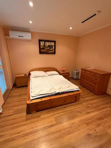 a bedroom with a bed and a wooden floor at Penzion Anička in Klokočov