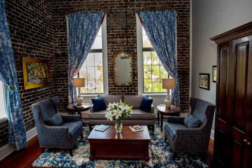 a living room with a couch and two chairs at East Bay Inn, Historic Inns of Savannah Collection in Savannah