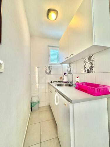 a white kitchen with a sink and a counter at Apartments Janda Bijela in Bijela