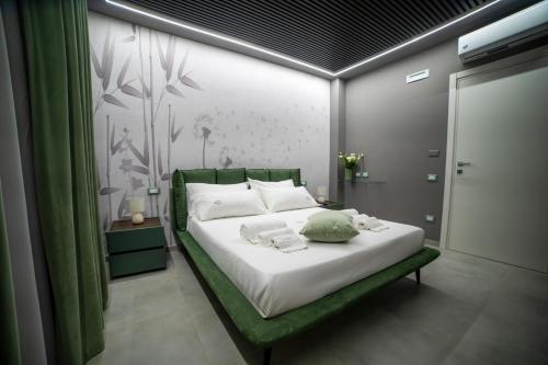a bedroom with a white bed with a green bed frame at Tree Luxury in Baronissi