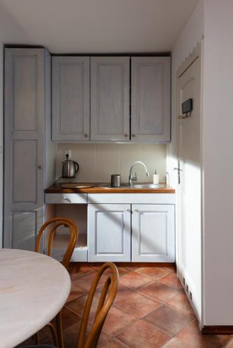 a kitchen with white cabinets and a table at Apartamenty Pod Bocianem in Ojców