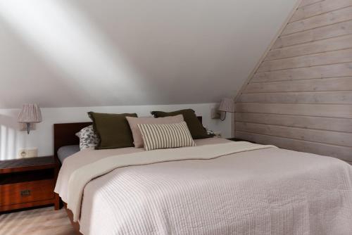 a bedroom with a large bed with white sheets at Apartamenty Pod Bocianem in Ojców