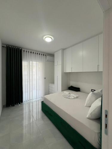 a bedroom with a bed with white cabinets and a window at RbNb Shengjin in Shëngjin