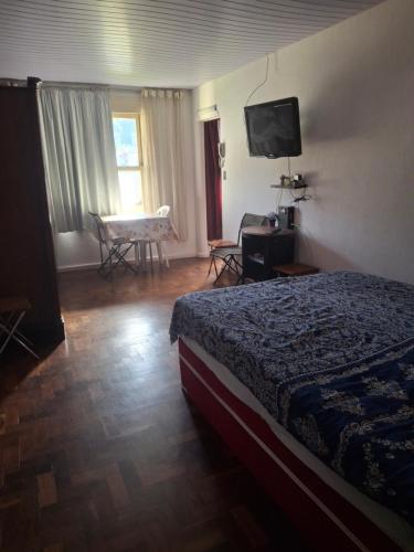 a hotel room with a bed and a television at Apartamento Teresópolis alto in Teresópolis