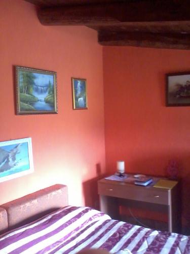 a bedroom with orange walls and a bed and a desk at Chalet Vista Lago in San Gregorio