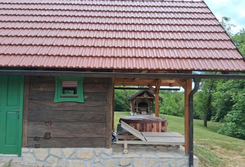 a small wooden cabin with a red roof at Bakina iža in Duga Resa