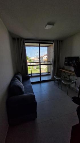 a living room with a couch and a large window at Apartment in Praia de Formosa in Cabedelo