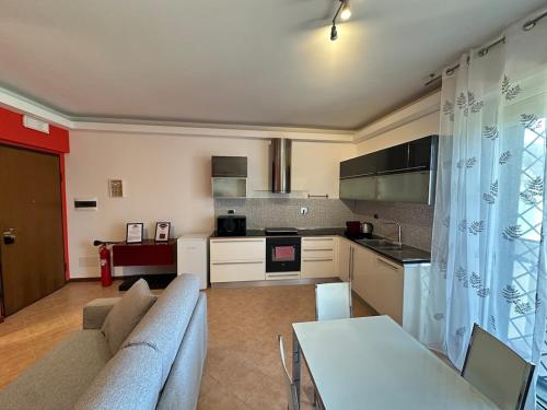 a living room with a couch and a kitchen at Roma Infernetto Escape apt 4 guest 1bedr 280mq terrace in Casal Palocco