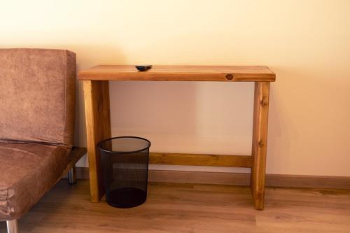 a wooden table in a room next to a couch at Hospedería La Bogadera in La Robla