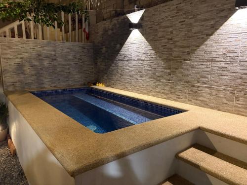 a swimming pool in a room with a brick wall at Casa Moka Amarilla in La Peñita de Jaltemba