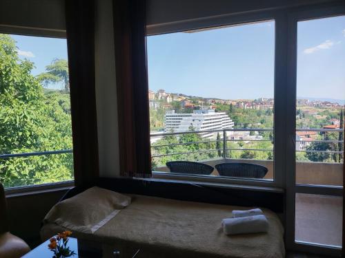a room with two large windows with a view at Hotel Avis in Sandanski