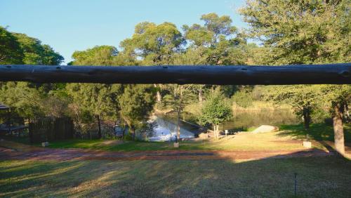a view of a yard with trees and a pond at Mologa River Lodge in Rust de Winter