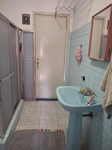 a bathroom with a blue sink and a shower at Apartamento Teresópolis alto in Teresópolis
