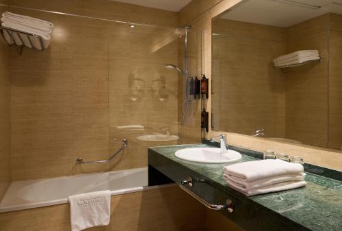 a bathroom with a sink and a tub and a mirror at Senator Granada in Granada