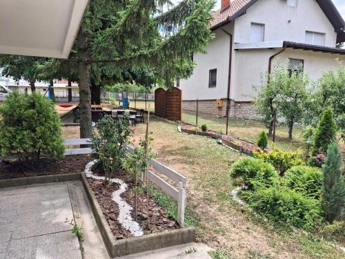 a garden with trees and plants in front of a house at Avalski put in Grkova