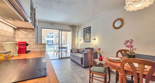 un salon avec une table et un canapé dans l'établissement Le Cannes Beach 161 - cosy, terrasse & piscine, à Cannes