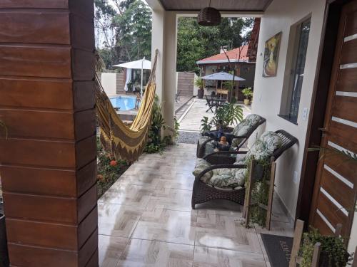 a porch with rocking chairs and a hammock at POUSADA NOSSO CANTO ALTER in Alter do Chao
