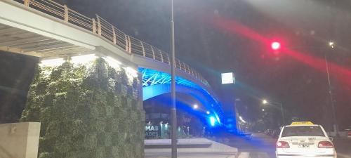 een witte auto die 's nachts onder een brug rijdt bij Amador Lucero apart II in San Miguel de Tucumán