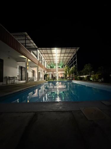 a swimming pool in front of a building at night at Welcome Inn in Grand Baie
