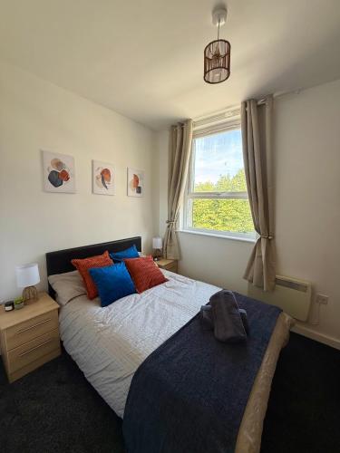 a bedroom with a bed and a window at Zelena Luxurious Apartment, Private Parking, Fast Wi-Fi, Self Check-In Anytime Perfect For Late Arrivals, 5 Minutes to Old Trafford Stadium in Manchester