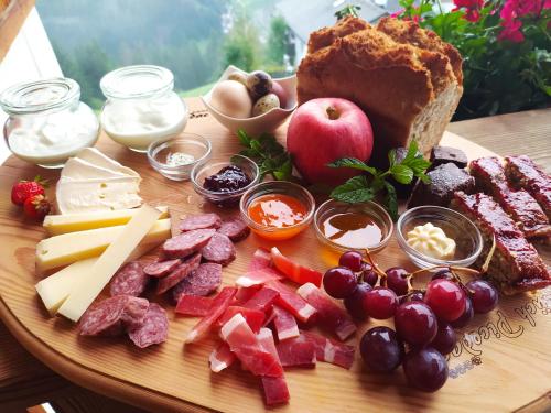 een bord eten met vlees, kaas, fruit en brood bij Farm apartment I neni in Lovara