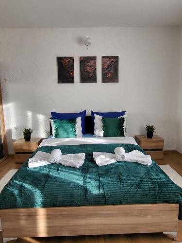 a bedroom with a large bed with towels on it at Apartman A in Livno