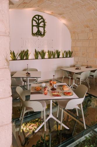 a restaurant with tables and chairs with food on them at Innesto Rooms - Monopoli in Monopoli