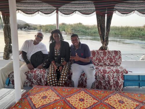a group of three people sitting on a boat at Habob Nubian Guest House in Aswan