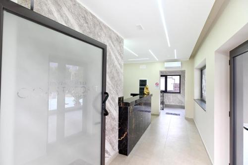 a hallway with a glass door leading into a room at Coast To Coast - Rooms & Pool! Camere moderne e piscina in Sant'Egidio del Monte Albino