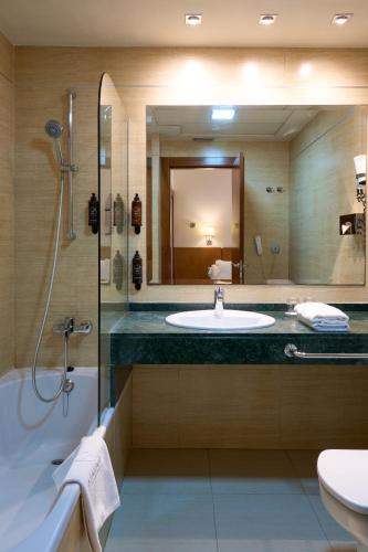 a bathroom with a sink and a shower and a mirror at Senator Granada in Granada