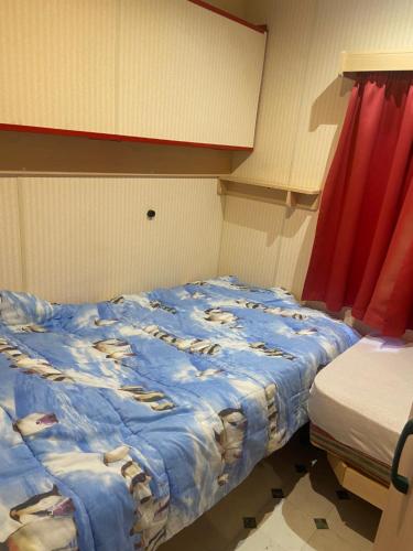 a bedroom with a bed with a blue comforter at Le Cèdre in Montlay-en-Auxois