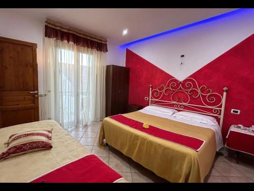 a bedroom with two beds and a red wall at vecchio west in Agerola