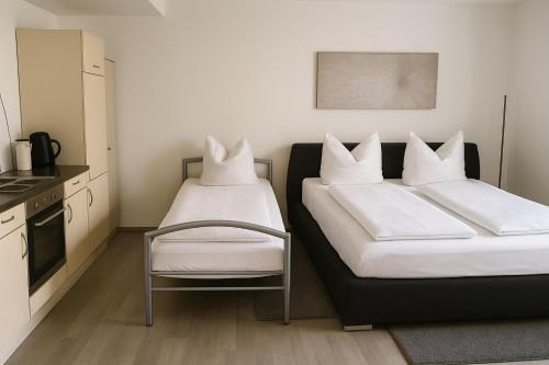 two beds in a kitchen with white pillows on them at Ferienwohnung Panoramablick in Sinsheim