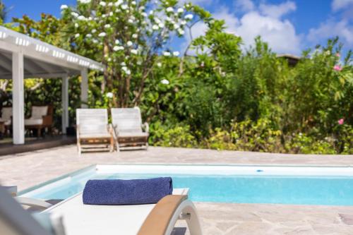 a pool with two chairs and a table and avisor at Piscadera Bay Resort 79 in Willemstad