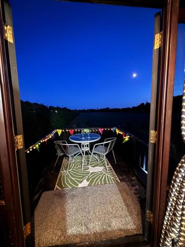 a view of a table and chairs on a balcony at Quex Livery Glamping in Birchington