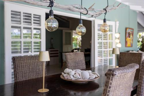 a dining room with a table with chairs and lights at Piscadera Bay Resort 79 in Willemstad