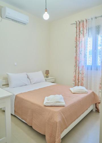 a white bedroom with a bed with two towels on it at Kythira echoes stay - Lithari in Kythira
