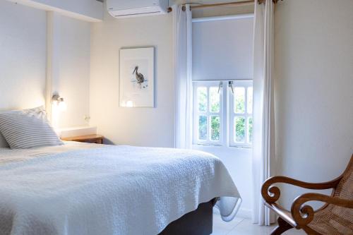 a white bedroom with a bed and a window at Piscadera Bay Resort 79 in Willemstad