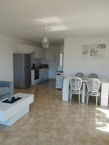 a kitchen and living room with a table and chairs at Appartement Le Recantou in Cap d'Agde