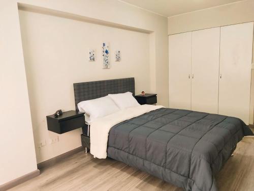 a bedroom with a large bed and white cabinets at Departamento amplio y céntrico-Terrazas in San Antonio