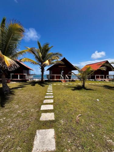 Un camino de piedra en un campo con palmeras. en Cabin over the sea on Guarsidub Island, en Panamá