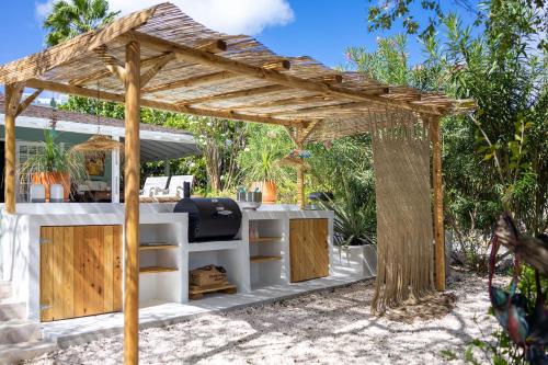 an outdoor bar with a wooden pergola at Piscadera Bay Resort 79 in Willemstad
