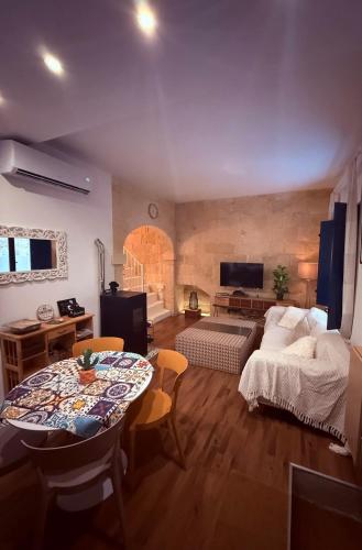 a living room with a bed and a table in a room at Il-Maxtura - Charming 17th Century House Of Character in the Historical Three Cities in Cospicua