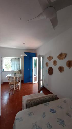 a bedroom with two beds and a dining room with a table at Le Case dei Pescatori - Casetta Faraglioni in Ponza